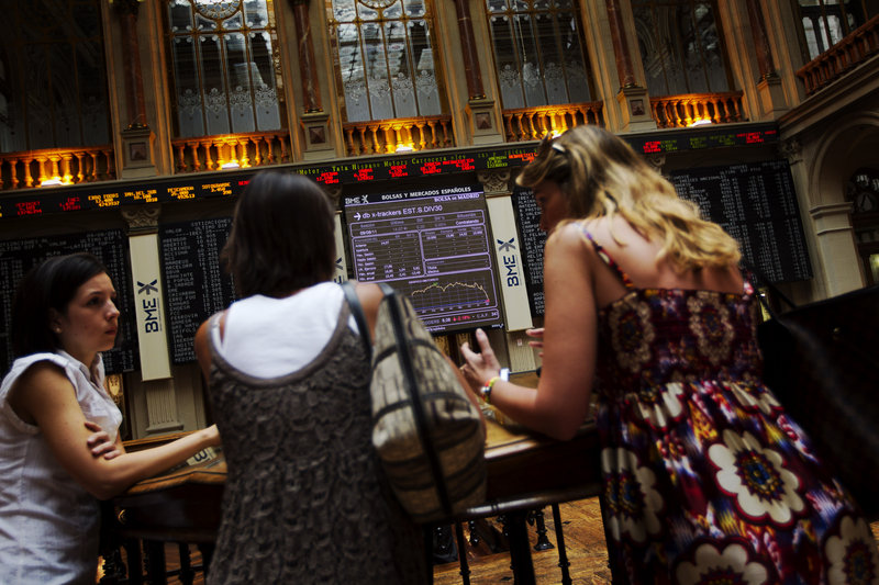 Women talk in front of the main screen at the Madrid Stock Exchange during volatile trading last week. Spain's finance minister insists her country is in no need of a bailout, but a potential default by Greece, Spain and Italy has undercut the banking system across the eurozone.