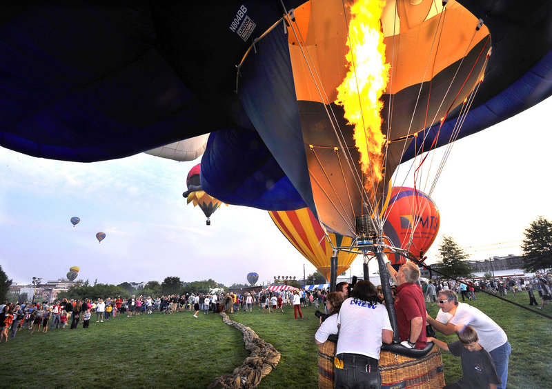 Dave Reineke of Mohomet, Ill., fills his 100-foot-high hot air balloon, named “Bud E. Beaver,” while his crew tries to keep it grounded as balloons are launched from Railroad Park in Lewiston during the Great Falls Balloon Festival.