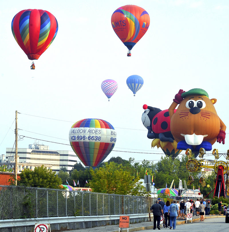 Early risers watch as hot air balloons are launched carrying passengers who paid $200 to $225 each to take a ride from Railroad Park in Lewiston on Saturday.