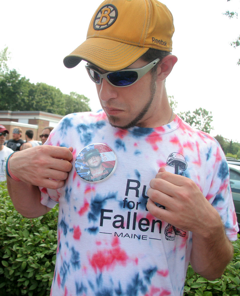 Shayne McDonald of Casco adjusts a button with a picture of his brother’s face. The relay honored 79 soldiers with ties to Maine who have died since Sept. 11, 2001.