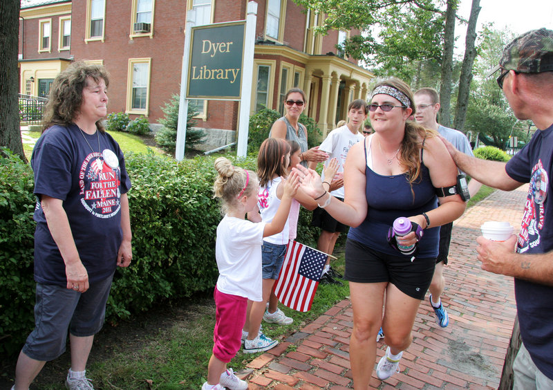Kathy McDonald of Casco, far left, and her husband, John Williams, far right, and family greet participants in the fourth Run for the Fallen Maine on Sunday in Saco. Their son Sgt. Edmund W. McDonald was killed in Kabul, Afghanistan, in 2007.