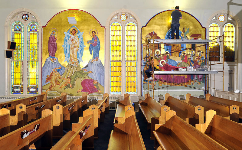 George S. Papastamatiou, an iconographer, paints lettering as his assistant, Christos Kazanzides, works below him on the scaffolding at Holy Trinity Greek Orthodox Church in Portland. They are working on a mural portraying the Dormition of the Virgin Mary. The mural to their left, of the Transfiguration, was painted in the fall of 2010.