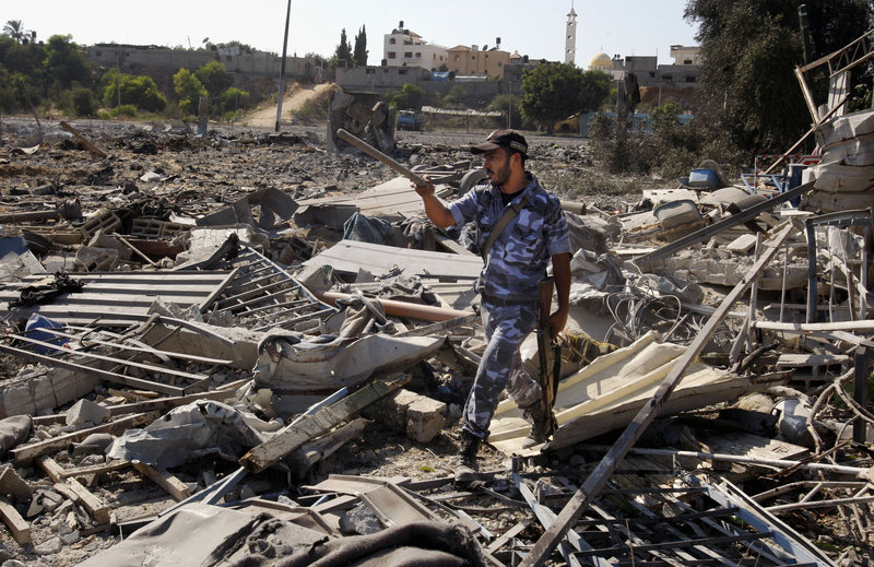 A Hamas security official inspects damage at a training camp after an Israeli airstrike in Gaza City on Sunday, as diplomats scrambled to keep violence from escalating.