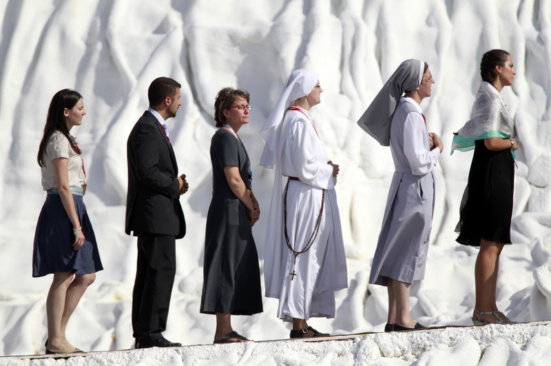 Worshippers line up to receive communion Sunday from Pope Benedict XVI during a Mass at an airfield near Madrid.