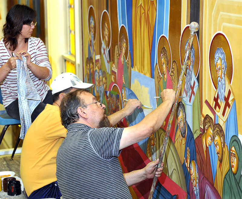 George S. Papastamatiou, right, adds details to a mural depicting the Dormition of the Virgin Mary, as his wife, Brunilda Rizaj-Papastamatiou, left, and his assistant, Christos Kazanzides, help finish the original creation.