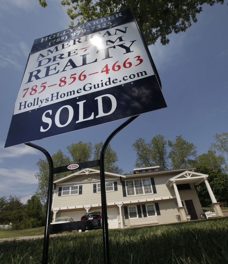 A sold sign stands in front of a home in Lawrence, Kan. The troubled housing market is hurting the broader economy.