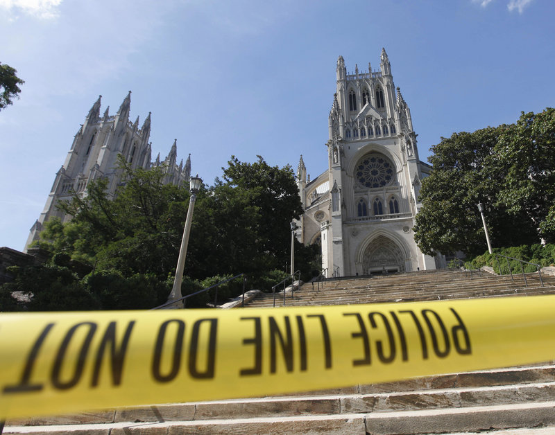 Police tape cuts off access to the National Cathedral in Washington on Tuesday after a piece of the left spire on the tower at right broke off when a 5.8-magnitude earthquake rumbled across much of the East Coast.