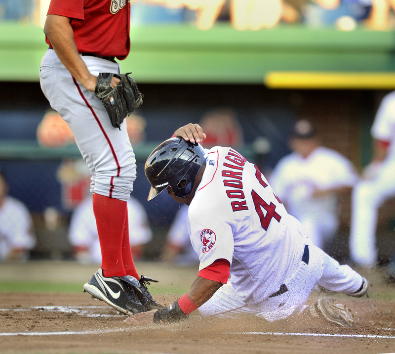 Reynaldo Rodriguez of the Portland Sea Dogs slides across the plate Tuesday night, scoring on a wild pitch in the second inning. It was the only run for Portland; the Harrisburg Senators emerged with a 4-1 victory before a sold-out Hadlock Field crowd.
