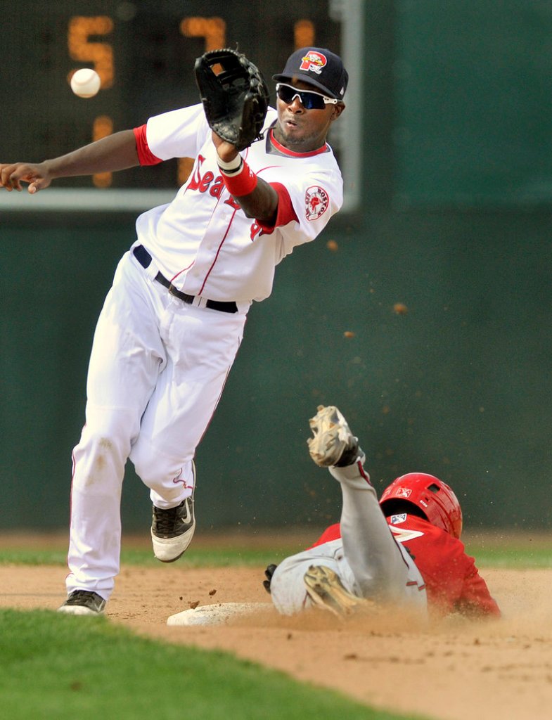 Second baseman Oscar Tejeda of the Sea Dogs pulls in an errant throw Wednesday as Archie Gilbert of the Harrisburg Senators steals a base in the eighth inning of Harrisburg's 9-3 win. Portland has lost seven straight.