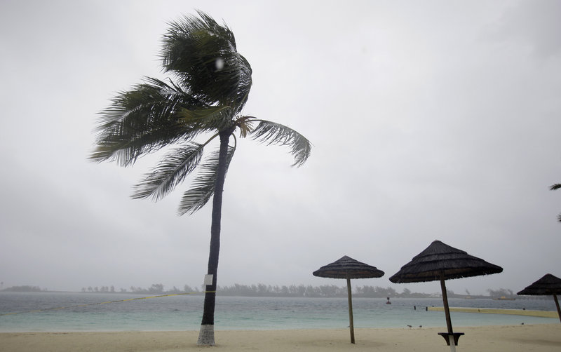 Palm trees bend as rain and wind from Hurricane Irene hit a beach Wednesday in the Bahamian capital of Nassau. Irene was a Category 4 storm Wednesday night, with winds up to 135 mph.