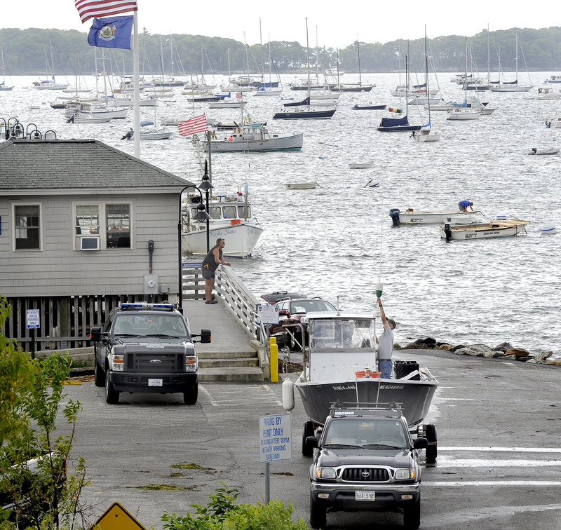 Boat owners haul their vessels from the water at Falmouth Town Landing on Thursday. Hundreds of watercraft moored here and all along the coast are potentially threatened by the approaching Hurricane Irene, which is on a track to reach Maine as early as Sunday.