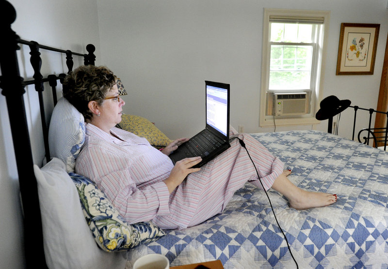 Rabbi Alice Goldfinger, who is recovering from a brain injury, works on a post for her blog, Brainstorm, in her bedroom at her home in Falmouth.