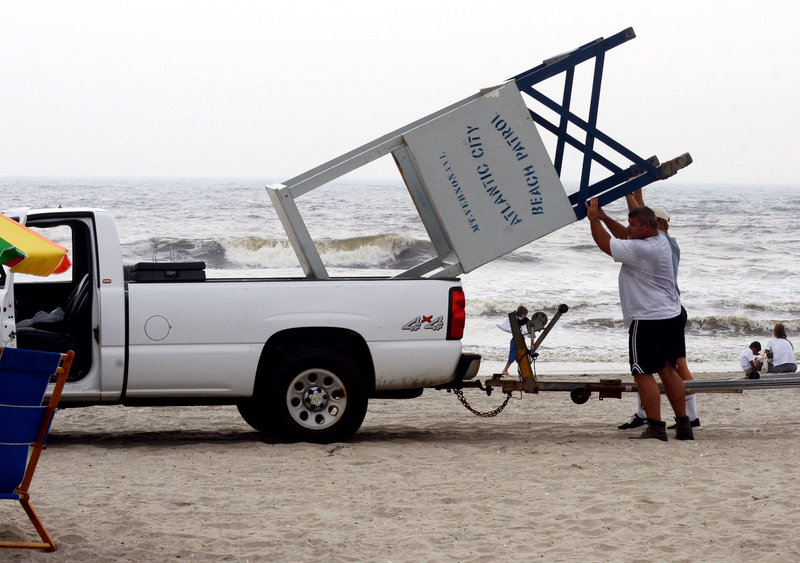 Lifeguard John Malecki and Lt. John Ammerman put a lifeguard stand in a pickup truck Thursday as they clear the beach in Atlantic City, N.J., ahead of Hurricane Irene.
