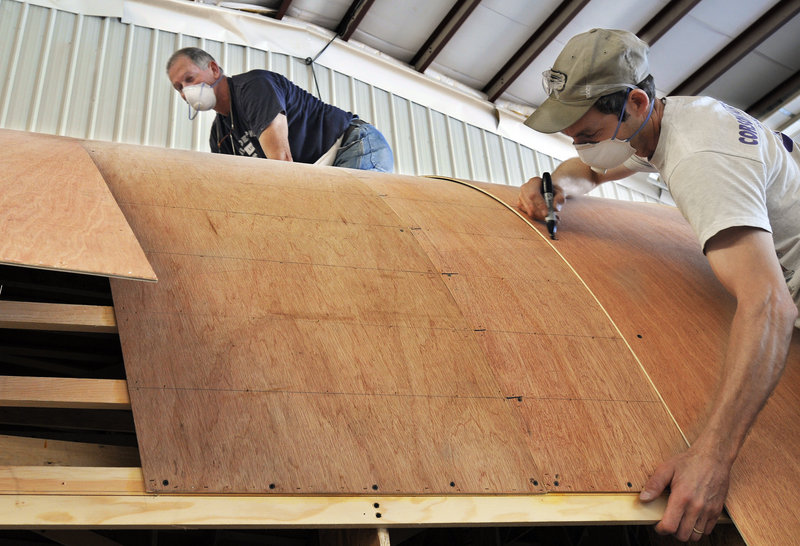 Carpenters Bill Harjula and Jeff Mank work on the hull of a new boat at Lyman-Morse Boatbuilding in Thomaston.
