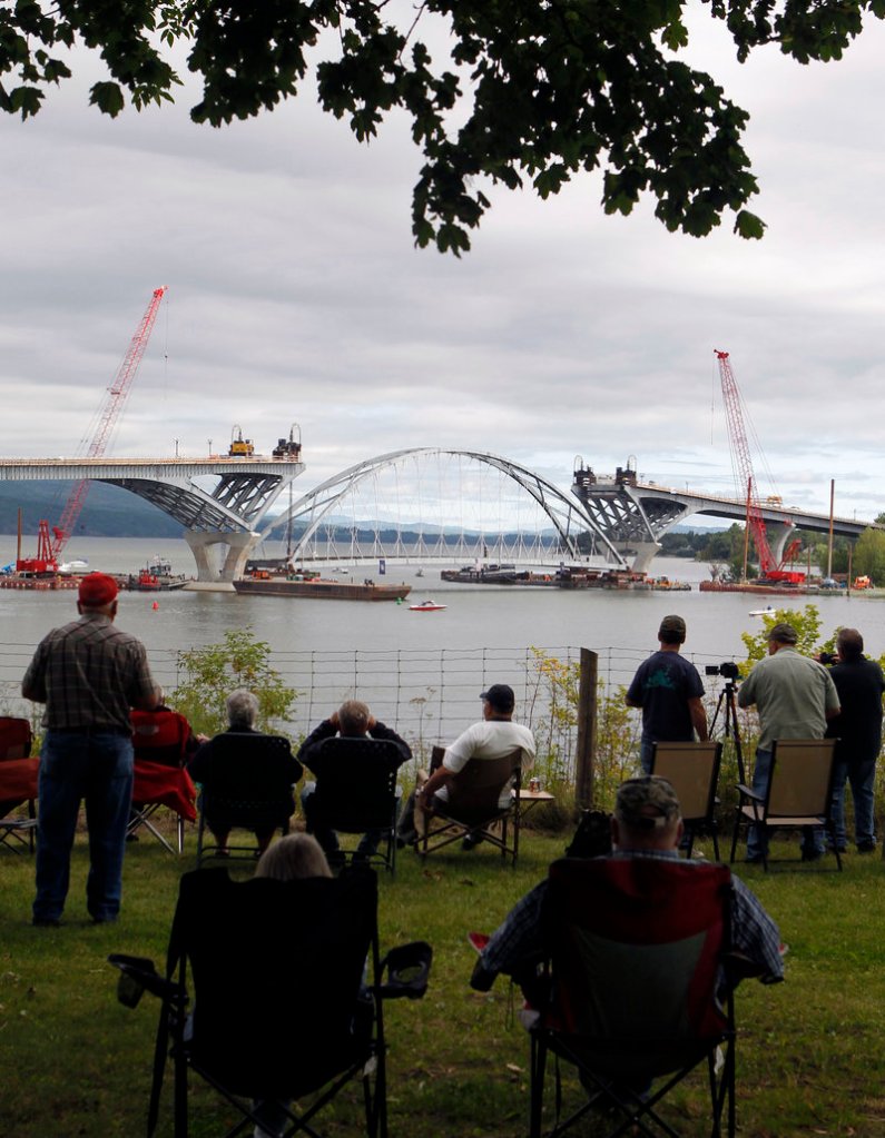 People in Crown Point, N.Y., watch Friday as the center arch of the Lake Champlain Bridge linking Crown Point and Addison, Vt., is positioned before being lifted into place.