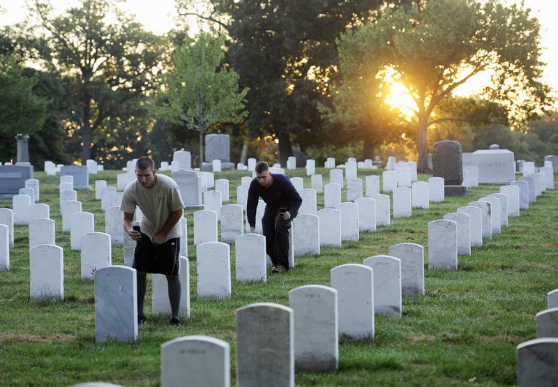 Soldier of the Army Old Guard photograph headstones at Arlington National Cemetery at sunrise on Wednesday. Their work will help update and fully digitize the cemetery's maps.