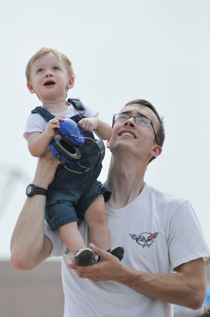 Steve Martin of Portland holds up his 14-month-old son Reid to watch the Great State of Maine Air Show at the former Brunswick Naval Air Station on Saturday.