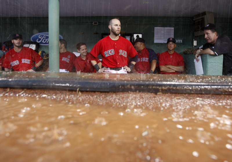 Dustin Pedroia gets a good look at the rain as the Red Sox take shelter in the dugout during a seventh-inning rain delay Saturday in the opener of a doubleheader with the A’s.