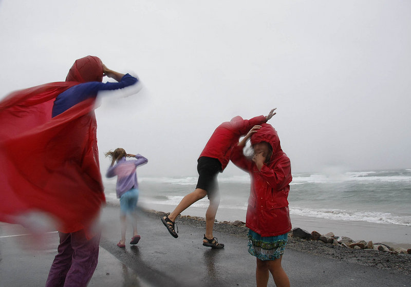 Kristen Day, left, of Boston feels the powerful winds of Tropical Storm Irene with her family at Ogunquit Beach on Sunday while on vacation.