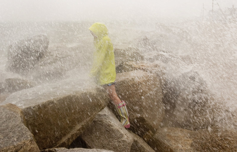 Sarah Casey, 10, of Saco gets soaked by the spray of a wave at high tide on Surf Street in Saco during Hurricane Irene on Sunday.