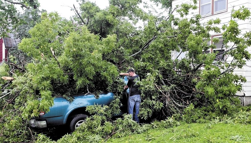 Joe Fox surveys the damage to his 1997 Ford truck after a tree fell on it Sunday at his home on Vigue Street in Waterville. Fox believes the high wind from Tropical Storm Irene toppled the tree. "I heard a hellacious crash," Fox said. He estimated damage to be about $2,000.