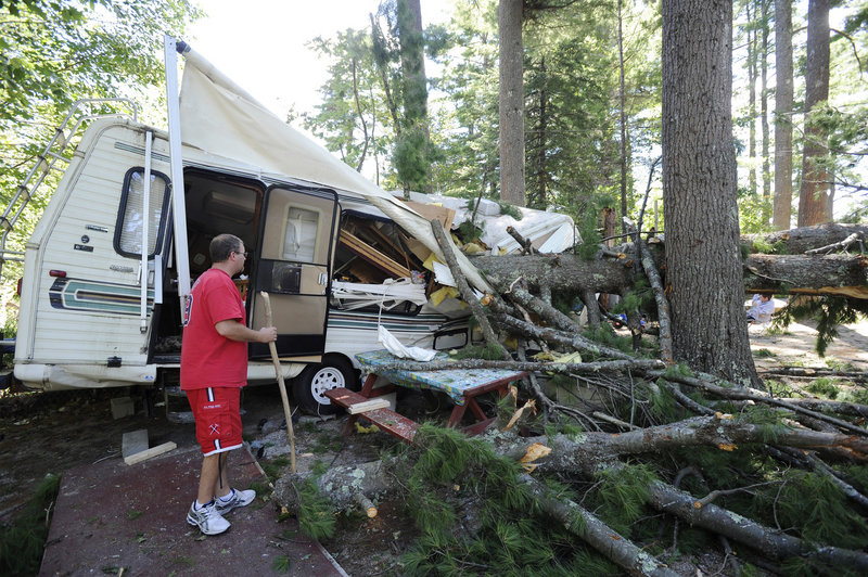 Matthew Fletcher checks the damage done to his 28-foot camper when a pine tree fell during Sunday’s storm along Sebago Lake. Fletcher and his fiancee, from Canton, Mass., had left the camper several hours earlier to seek shelter.