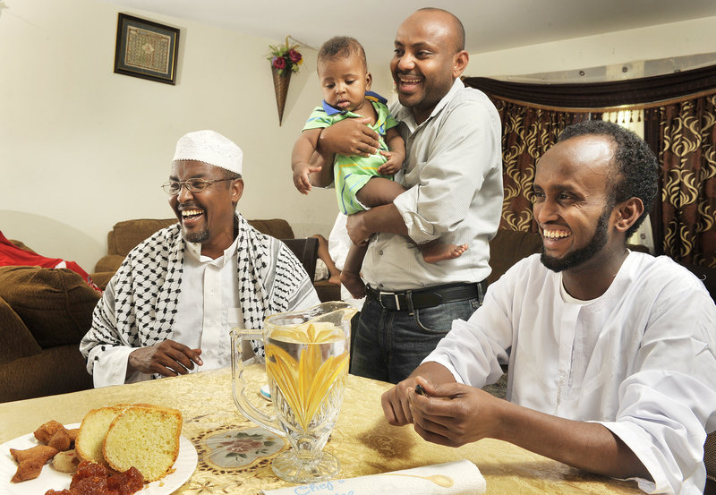 Friends Yasin Atoor, left, Hamza Haadoow and his son, and Abdikadir Noor and their families gather to observe the end of Ramadan.