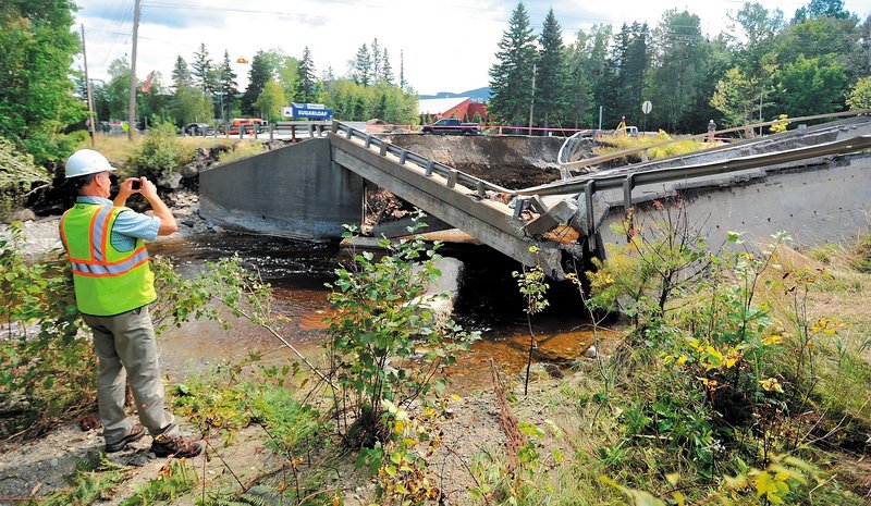 Ted Clark, a project manager for Reed & Reed General Contractors, assesses the damage to the bridge that failed on Route 27 in Carrabassett Valley during Sunday’s storm. The bridge was to be repaired within the next 12 months because of a design flaw in its support system.