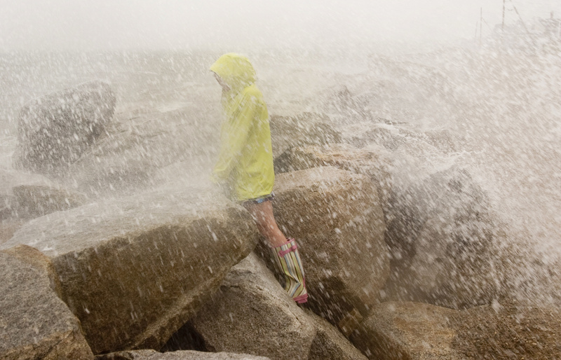 Sarah Casey, 10, of Saco gets soaked by the spray of a wave at high tide on Surf Street in Ferry Beach, Saco, during Tropical Storm Irene today.