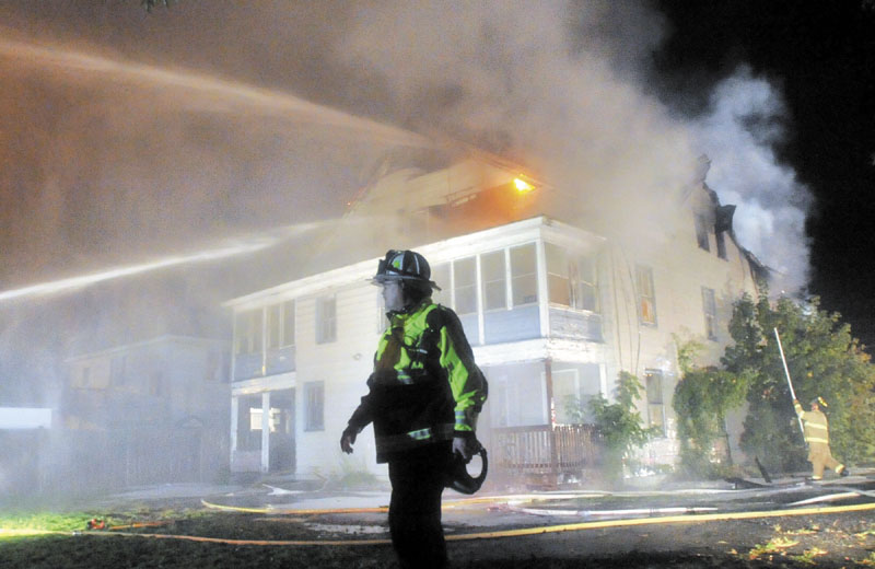 ON THE JOB: Waterville Fire Chief Dave LaFountain stands in front of a three-story apartment building as it burns Monday night on Water Street in Waterville. LaFountain is concerned about new policies from the State Fire Marshal's office due to budget cuts that scales back cases that fire investigators respond to.