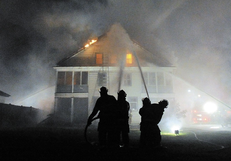 BATTLING: Firefighters from the Waterville and Winslow fire departments responded to a blaze at an apartment building on Water Street in Waterville Monday night.