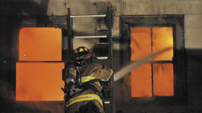 TEAMING UP: Firefighters from the Waterville and Winslow fire departments responded to a blaze at an apartment building on Water Street in Waterville Monday night.