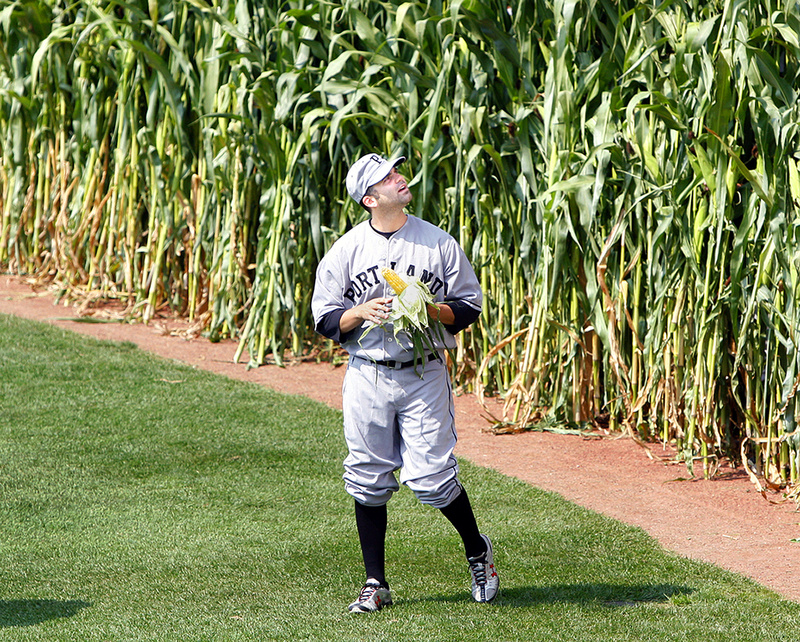 Kyle Fernandes of the Portland Sea Dogs emerges from the corn in center field shucking a piece of corn during the Field of Dreams day before the start of today's game against the New Hampshire Fisher Cats at Hadlock Field.