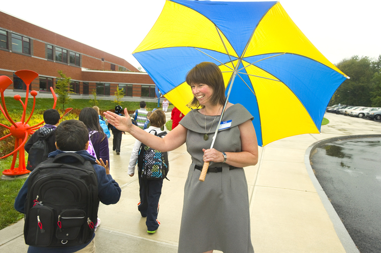 Beverly Coursey, principal at the new Ocean Avenue Elementary School in Portland, greets arriving students today.