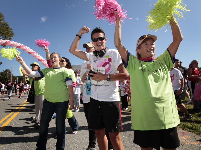 Sherman Kendal of Falmouth, right,, Alley Smith of Lewiston and Katelyn LaBreck of Standish cheer for fellow runners at the Race for the Cure on Back Cove today.