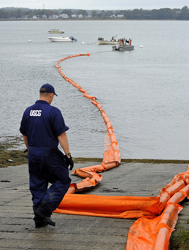 Brian Wereda of the US Coast Guard assists as a boat pulls a 500-foot harbor boom from the shore of Portland’s Back Cove Tuesday, during an oil spill readiness exercise organized by the Coast Guard and the Maine DEP.