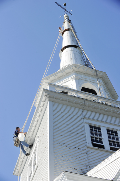 MMR employees Nick Gustafson, top, and Dean Pelotte work on the church steeple.