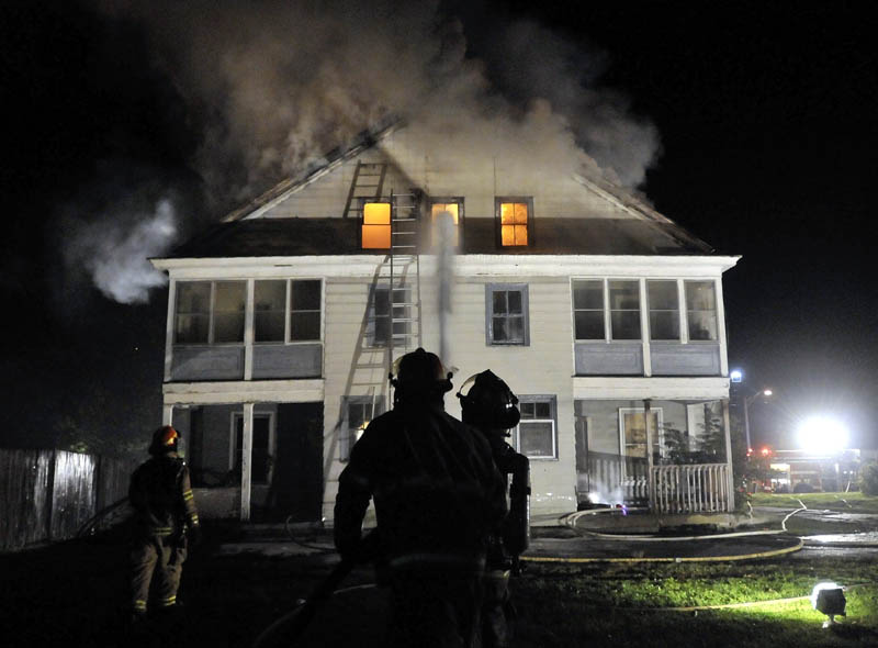 Staff photo by Michael G. Seamans Firefighters from Waterville and WinslowFire Departments responded to a structure fire on Water Street Monday evening. The apartment building was a total loss.