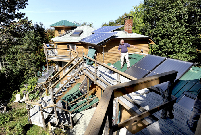 Michael Mayhew shows some of the solar panels atop his Boothbay Harbor home's many roof lines. The home will be included in Saturday's green building open house tour.