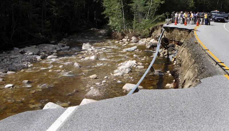 In this Aug. 31, 2011, photo, New Hampshire Gov. .John Lynch, among the crowd, inspects a section of the Kancamagus Highway where flash floods from Hurricane Irene washed out part of the road. The scenic highway through the White Mountains has been reopened.