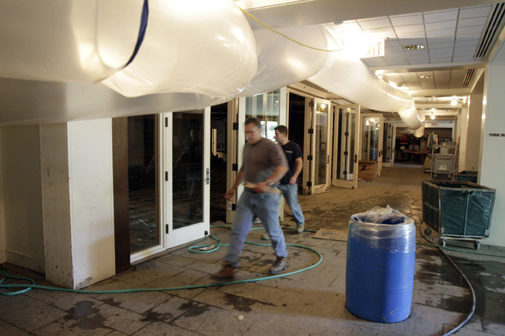 Workers walk through the flood-damaged basement conference center of the Woodstock Inn, which has closed for the month of September for repairs and cleanup.
