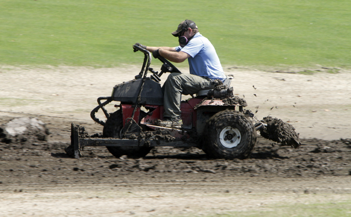 Scott Burton tries to move mud off the golf course at the Woodstock Inn resort today in Woodstock, Vt.