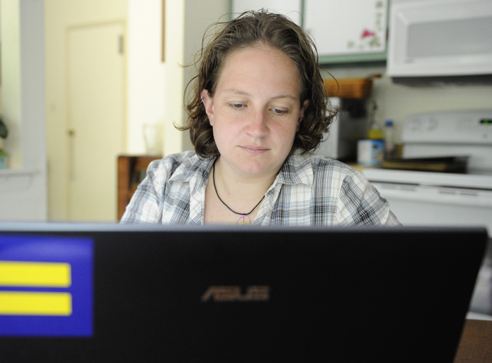 Catherine Devine, 22, reads instant messages on her laptop screen at her home in Kings Park, N.Y., on Monday. A new Associated Press-MTV poll of youth in their teens and early 20s finds that most of them – 56 percent – have been the target of some type of online taunting, harassment or bullying, a significant increase over just two years ago.