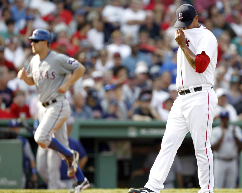 Boston Red Sox relief pitcher Felix Doubront, right, wipes his face after giving up a bases-loaded walk to Texas Rangers' Esteban German, allowing David Murphy, left, to walk home and score a run during the sixth inning on Sunday.