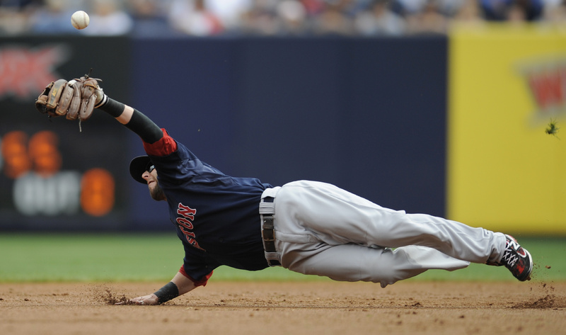 Dustin Pedroia of the Red Sox can't catch the ball during the first inning of the first game today against the Yankees at New York. The Red Sox lost, 6-2.