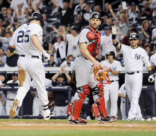 New York Yankees runner Mark Teixeira, left, scores as Boston Red Sox catcher Jason Varitek, front right, looks on during the first inning of the second game of a baseball doubleheader on Sunday at Yankee Stadium. Teixeira hit a two-RBI double and scored on a throwing error by Varitek.