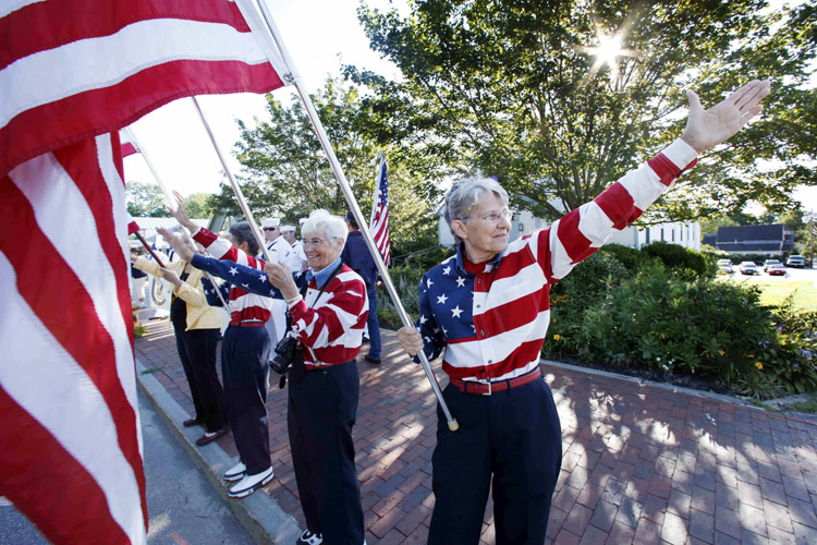 In this Aug. 23, 2011, photo, the Freeport Flag Ladies wave to cars in Freeport. The women, who have waved the American flag every Tuesday morning since 9/11, have dedicated their lives to encouraging the American spirit and supporting of U.S. troops in the war against terrorism.