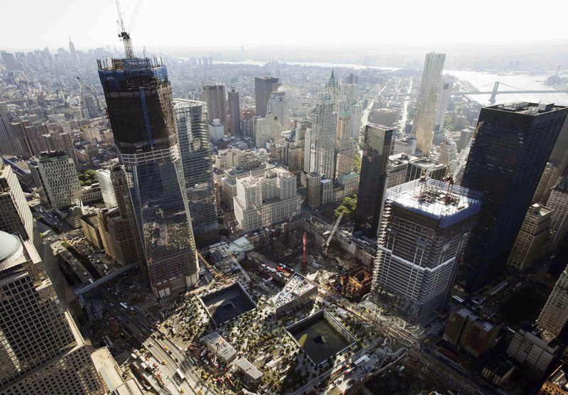 Construction continues at the World Trade Center in New York. One World Trade Center, left, rises above the lower Manhattan skyline followed by Four World Trade Center, lower right, with the square outlines of the almost-completed September 11 Memorial at lower center.