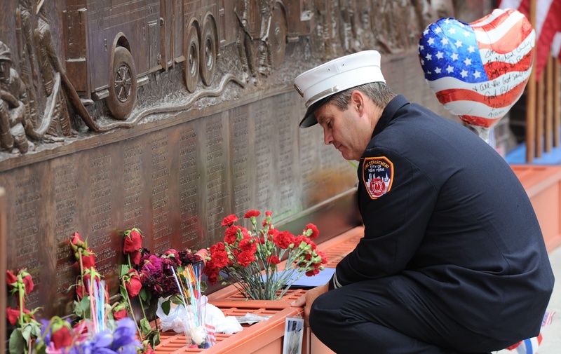A New York city firefighter pauses at the firefighters memorial wall that displays the names of victims of Sept. 11 at ground zero on the 10th anniversary of the terrorist attacks in New York today. Canada Canadian 9/11 9-11 nine eleven Sept 11 Sept. 11. Terror Terrorism plot NY NYC