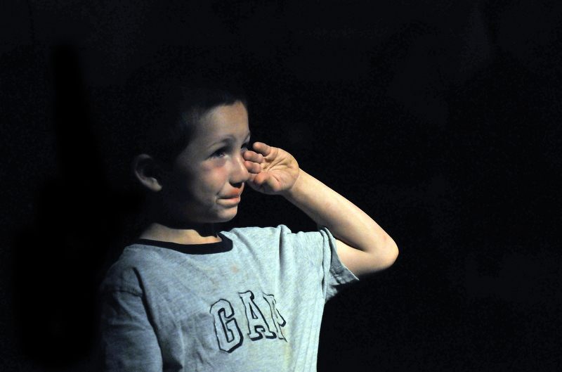 Staff photo by Michael G. Seamans Jasper Ruiz, 6, of North Anson, wipes a tear from his cheeck during the singing of the National Anthem at the beginning of the September 11th memorial sercvice at Champions on Main Street in Waterville Saturday.